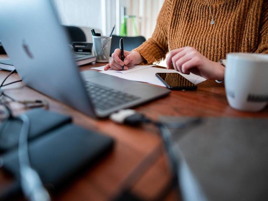 Eine Frau sitzt mit einem Laptop an einem Tisch im Homeoffice. Foto: Fabian Strauch/dpa