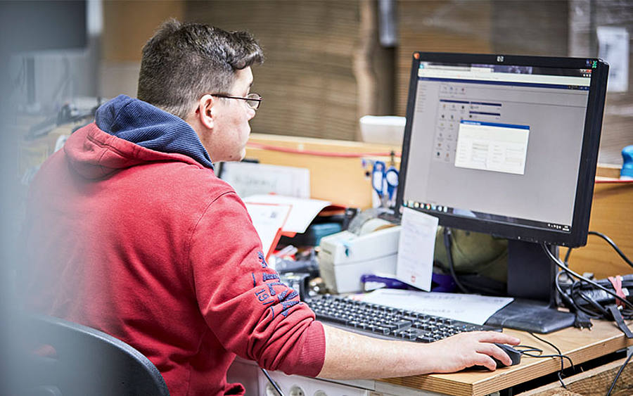 Mitarbeiter gibt Daten am PC ein