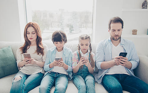 Smartphone-süchtige Familie auf dem Sofa