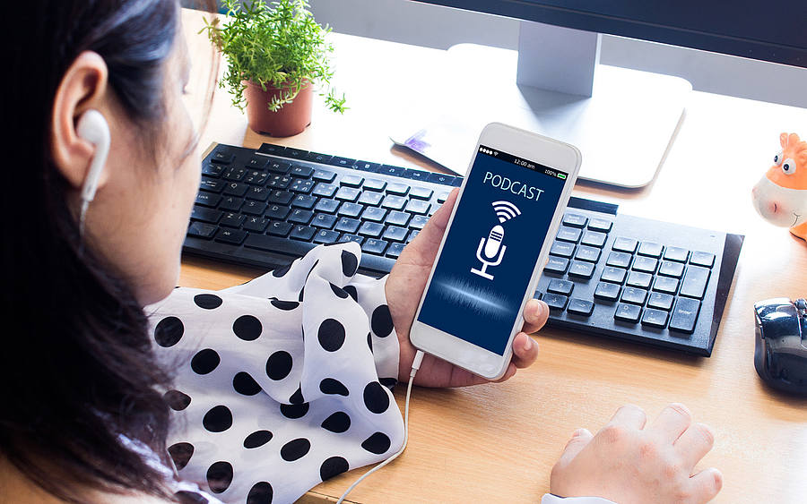 Frau hört Podcast übers Smartphone