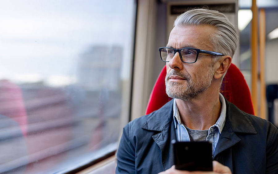 Mann in Zug mit Smartphone