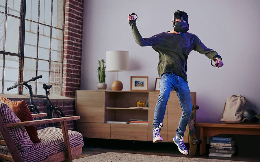 Junger Mann mit Oculus Quest in einem Wohnzimmer