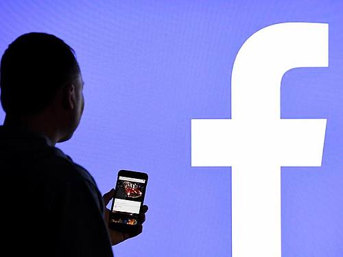 Das Facebook-Logo hinter einer Silhouette