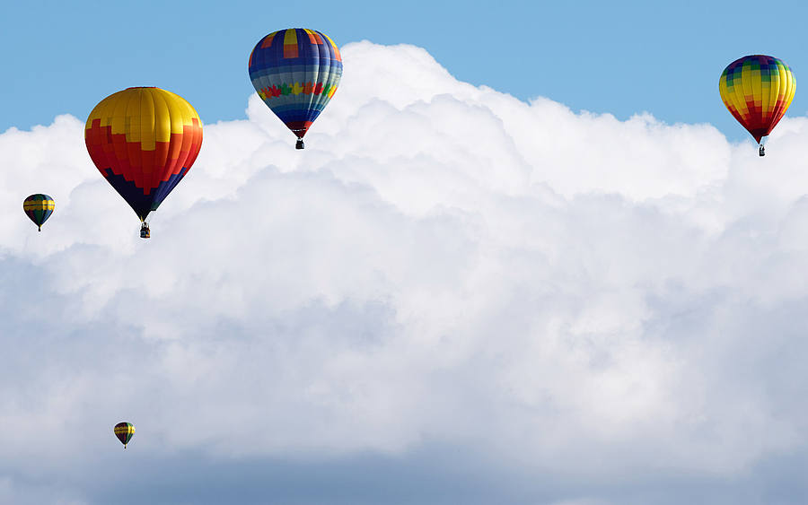 Mehrere Heißluftballons schweben in die Wolken