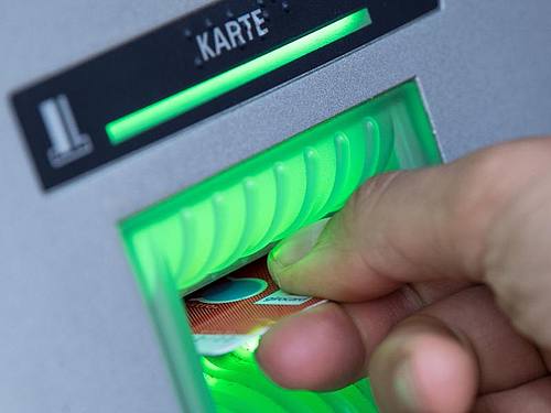 Eine Bankkundin steckt ihre Girokarte in einen Geldautomaten. Foto: Fabian Sommer/dpa/Symbolbild/Archiv
