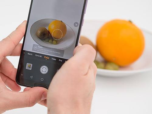 Die Künstliche Intelligenz in diesem Huawei Smartphone erkennt die Orange und richtet die Kamera für ein ansprechendes Food-Foto ein. Foto: Robert Günther/dpa-tmn