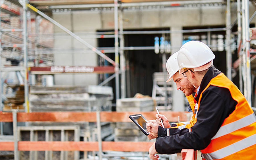 Zwei Männer mit Tablet auf der Baustelle