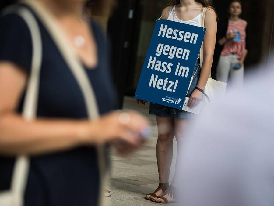 Eine Aktivistin der Nichtregierungsorganisation Campact steht mit einem Plakat mit der Aufschrift "Hessen gegen Hass im Netz" am Eingang zum Landesparteitag von Bündnis 90/Die Grünen in Hessen, Foto: Frank Rumpenhorst