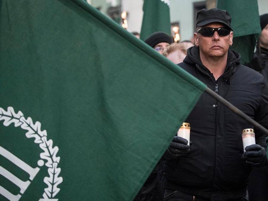 Mit Fahnen und Kerzen in der Hand gehen Demonstrationsteilnehmer der rechtsextremen Kleinstpartei «Der dritte Weg» während eines Marsches durch die Innenstadt von Fulda. Foto: Boris Roessler/dpa