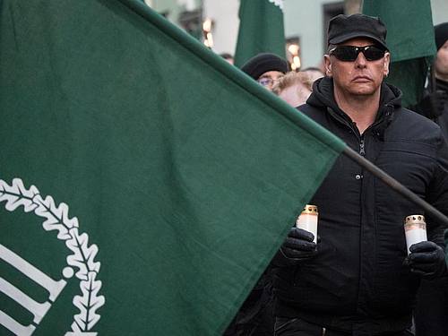 Mit Fahnen und Kerzen in der Hand gehen Demonstrationsteilnehmer der rechtsextremen Kleinstpartei «Der dritte Weg» während eines Marsches durch die Innenstadt von Fulda. Foto: Boris Roessler/dpa