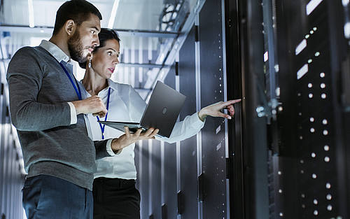 Menschen im Gespräch vor Server-Reihe