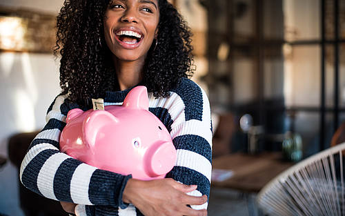 Junge Frau mit Sparschwein