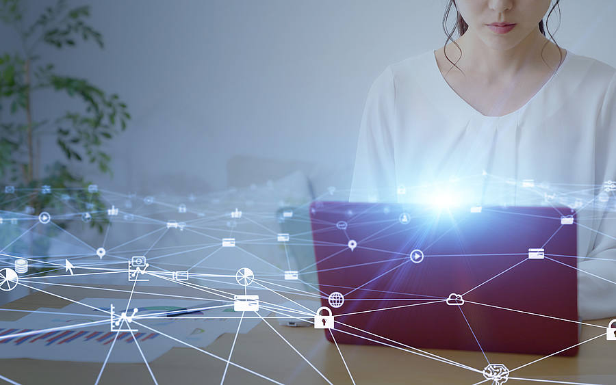 Frau am Notebook mit Netzwerkstruktur