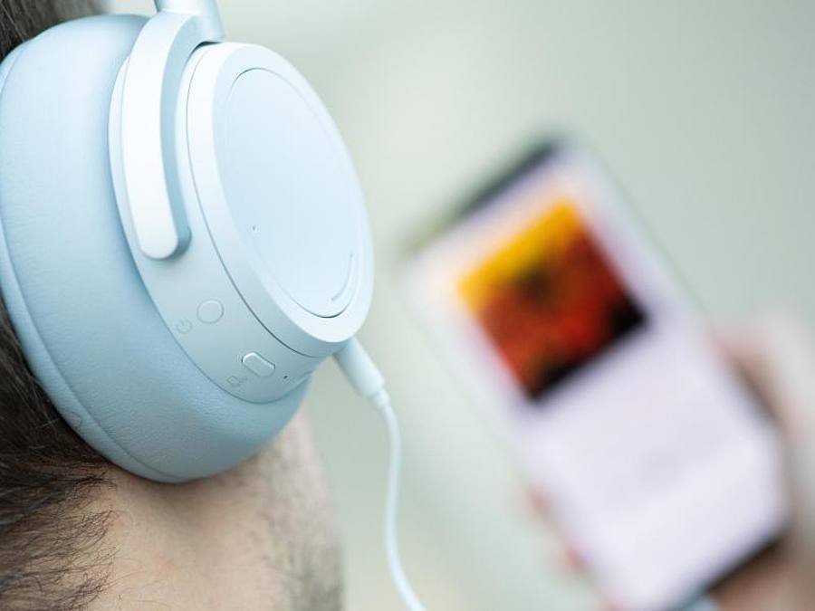 Ein junger Mann hört auf seinem Smartphone einen Podcast. Foto: Franziska Gabbert/dpa-tmn/dpa