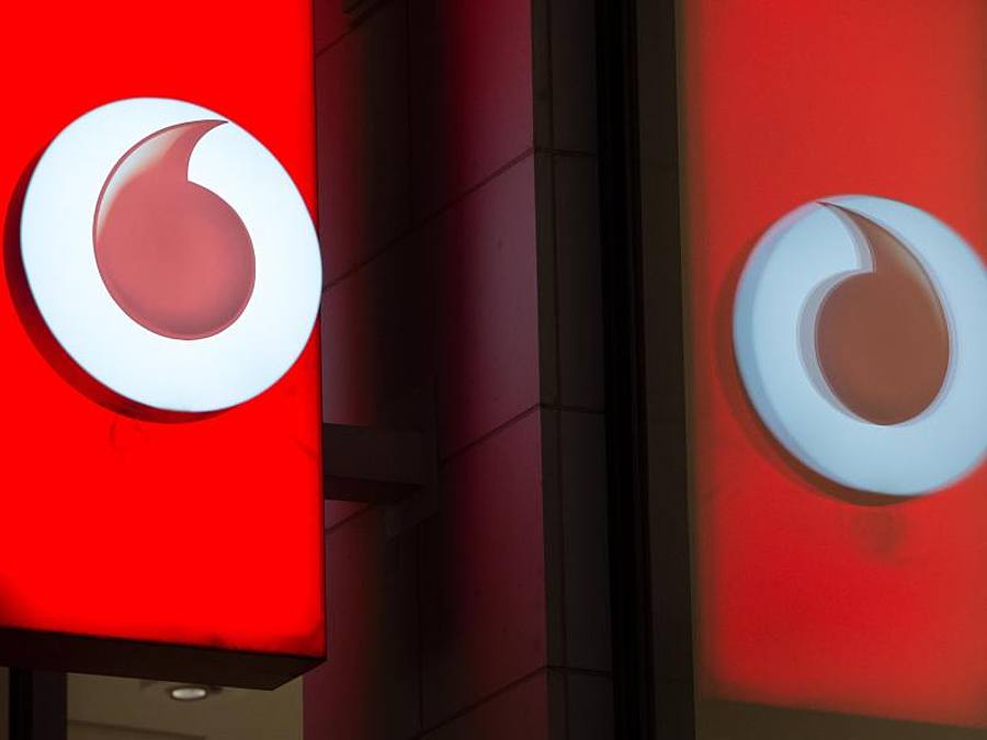 Das Logo von Vodafone spiegelt sich in der Fensterscheibe einer Verkaufsfiliale des Unternehmens. Foto: Rainer Jensen/dpa