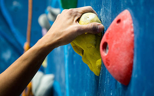 Frauenhand an der Kletterwand