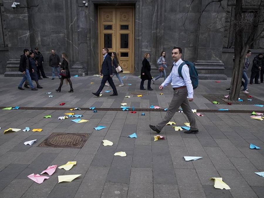 Fußgänger gehen an Papierfliegern vorbei, die von Demonstranten vor das Gebäude des russischen Geheimdienstes FSB am Lubjanka-Platz in der russischen Hauptstadt geworfen wurden. Foto: Pavel Golovkin/AP