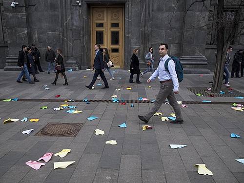 Fußgänger gehen an Papierfliegern vorbei, die von Demonstranten vor das Gebäude des russischen Geheimdienstes FSB am Lubjanka-Platz in der russischen Hauptstadt geworfen wurden. Foto: Pavel Golovkin/AP
