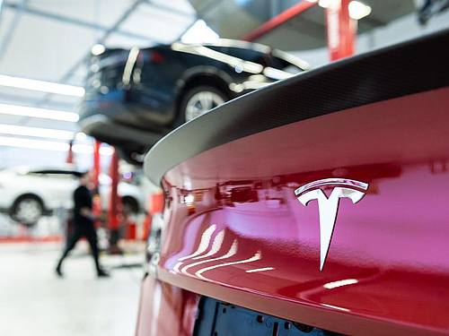 Das Logo des Fahrzeugherstellers Tesla auf einem Fahrzeug in einem Tesla Service Center. Foto: Silas Stein