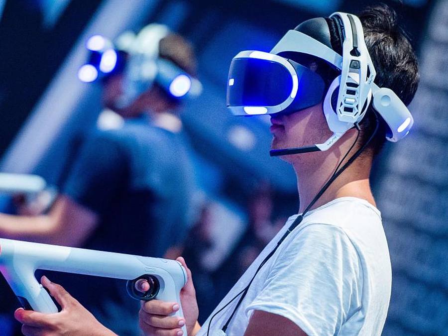Ein Besucher der Gamescom 2018 probiert an einem Stand ein Videospiel mit einer VR-Brille aus.