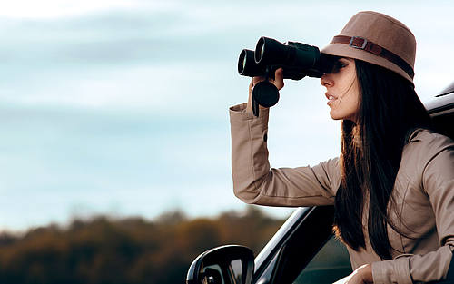 Frau schaut mit Fernglas