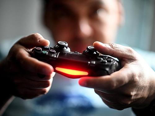 Ein junger Mann spielt mit der Spielekonsole Playstation vor dem Fernseher. Foto: Britta Pedersen/dpa-Zentralbild/dpa
