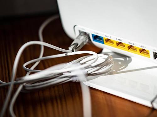 Ein LAN-Kabel steckt in einem WLAN-Router. Foto: Fabian Sommer/dpa