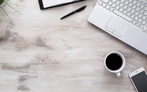 Schreibtisch mit Laptop und Smartphone