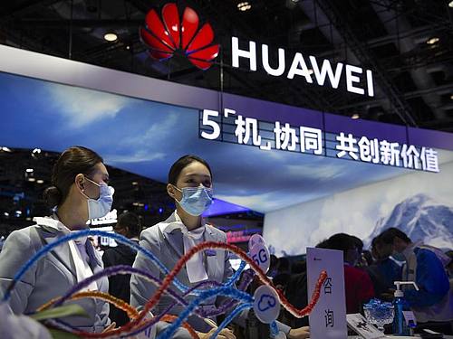 Mitarbeiter stehen an einem Stand des chinesischen Technologieunternehmens Huawei auf der PT Expo in Peking. Foto: Mark Schiefelbein/AP/dpa