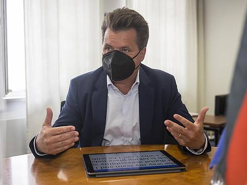 Jürgen Dusel, Behindertenbeauftragter der Bundesregierung, sitzt in seinem Büro an seinem Tablet. Die Schrift auf seinem Tablet ist vergrößert, damit er sie lesen kann. Foto: Nina Hansch/dpa