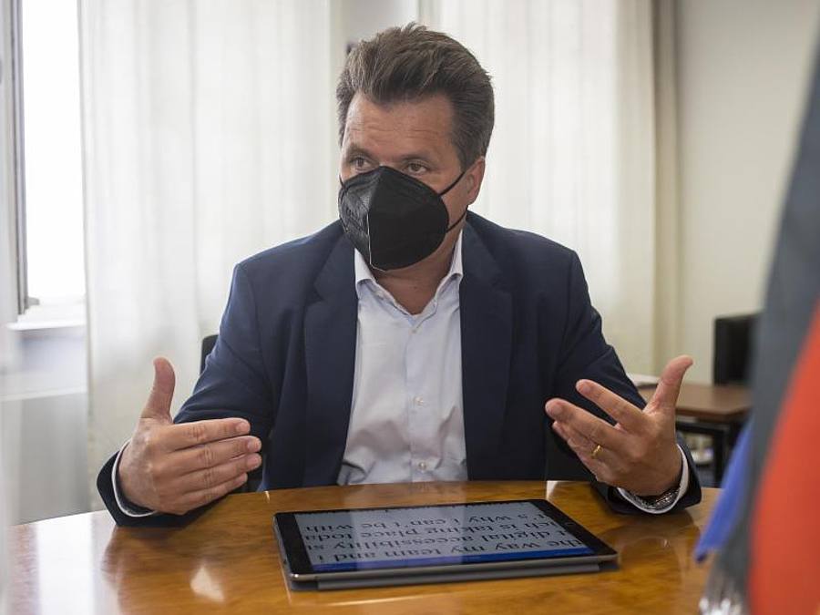 Jürgen Dusel, Behindertenbeauftragter der Bundesregierung, sitzt in seinem Büro an seinem Tablet. Die Schrift auf seinem Tablet ist vergrößert, damit er sie lesen kann. Foto: Nina Hansch/dpa