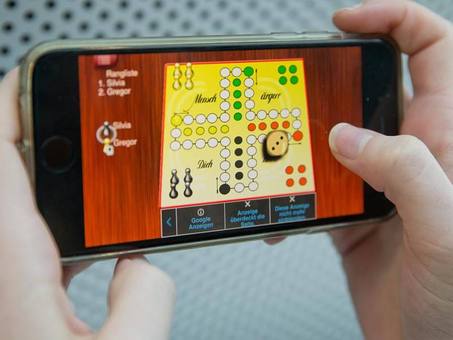Eine Frau spielt auf einem Smartphone. Foto: picture alliance / dpa