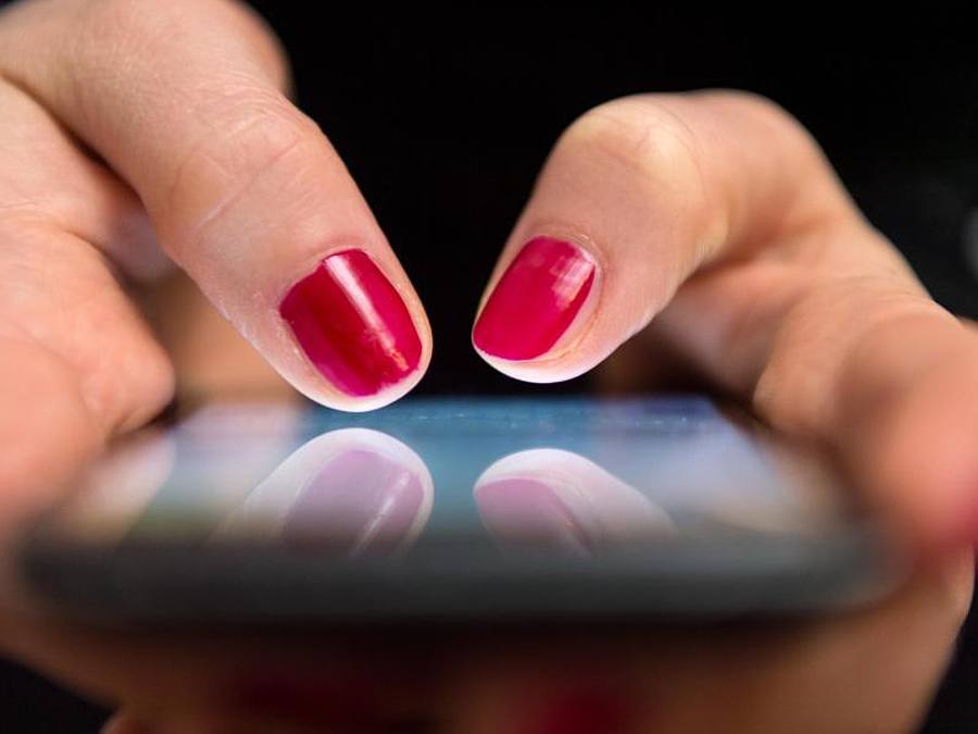 Eine Frau tippt auf einem Smartphone. Foto: Sebastian Gollnow/Illustration
