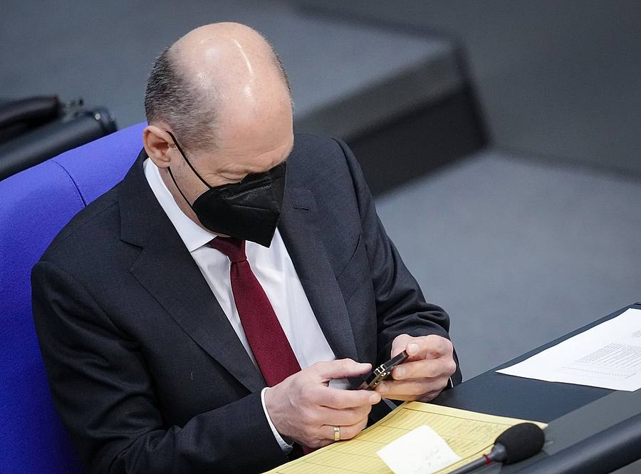 Bundeskanzler Olaf Scholz schaut im Bundestag auf sein Handy (Archivbild).