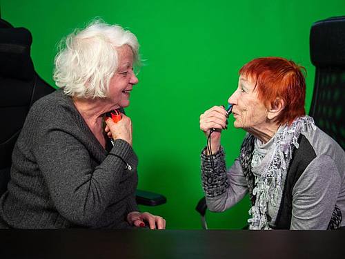 Evelyn Gundlach (r) und Ursula Cezanne (l) spielen in einem Berliner Studio an der Nintendo Switch ein Videospiel, bei dem man sich mit dem Controller rasieren muss. Foto: Arne Immanuel Bänsch