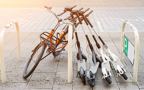 E-Tretroller lehnen an einem Fahrradständer