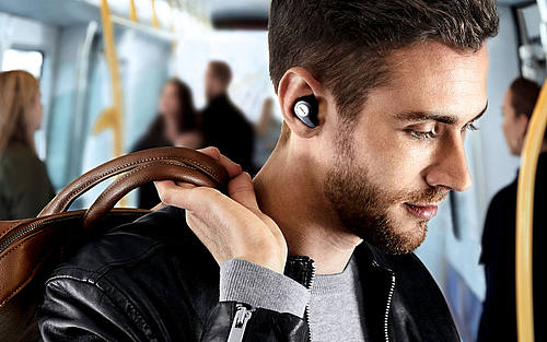 Mann in U-Bahn mit Jabra Elite 65T in den Ohren 