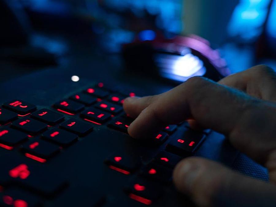 Finger tippen auf einer beleuchteten Tastatur. Foto: Nicolas Armer/dpa/dpa-tmn/Symbolbild