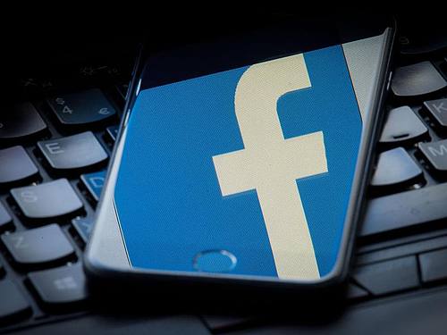 Das Facebook-Logo spiegelt sich auf einem Smartphone. Foto: Dominic Lipinski/PA Wire