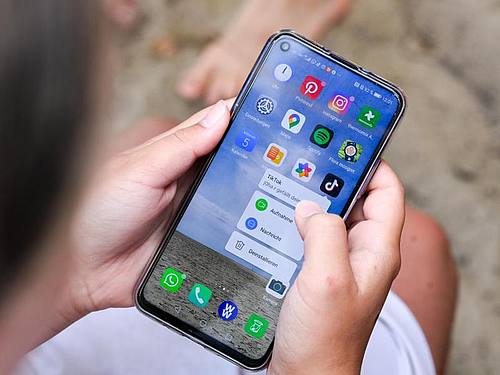 Ein Mädchen hält ein Smartphone in den Händen. Foto: Jens Kalaene/dpa-Zentralbild/ZB