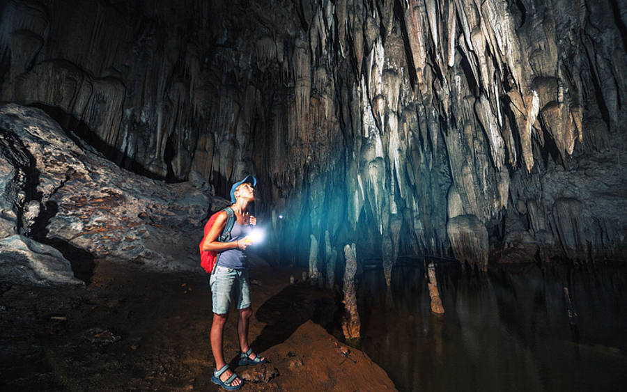 Forscherin erkundet dunkle Höhle 