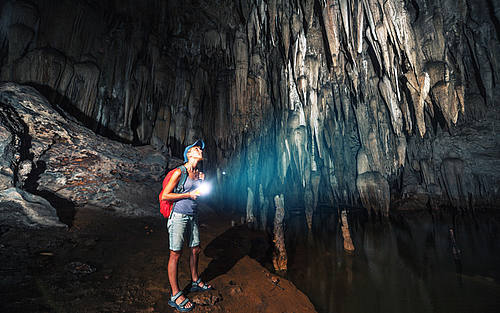 Forscherin erkundet dunkle Höhle 
