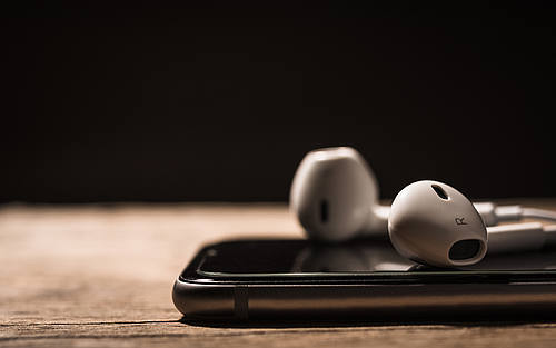Ein Smartphone mit In-Ear-Kopfhörern auf einem Tisch