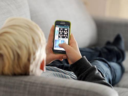 Ein Kind mit einem Smartphone. Wann ist der beste Zeitpunkt für das erste Gerät?. Foto: Tobias Hase/dpa