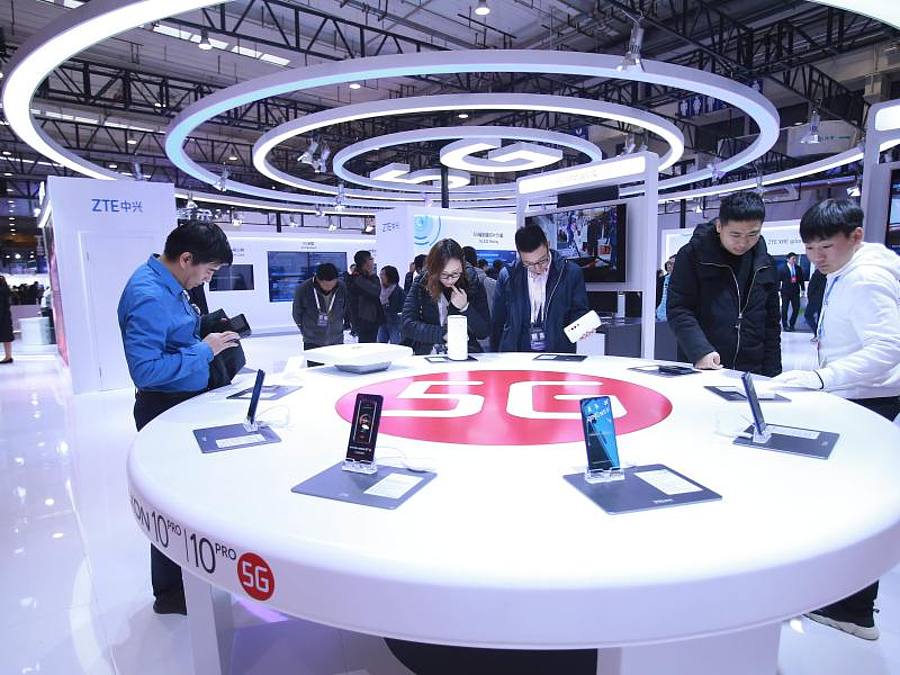 Besucher schauen in Peking neue Smartphones mit 5G-Technologie an. Foto: Chen Xiaogen/SIPA Asia via ZUMA Wire/dpa