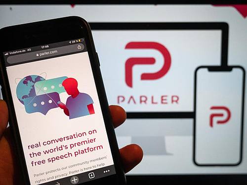 Auf einem Handy wird die Webseite der Social Media Plattform Parler angezeigt. Foto: Christophe Gateau/dpa
