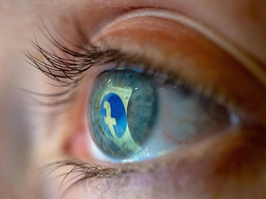 Das Facebook-Logo spiegelt sich in einem Auge. Foto: Mohssen Assanimoghaddam/dpa