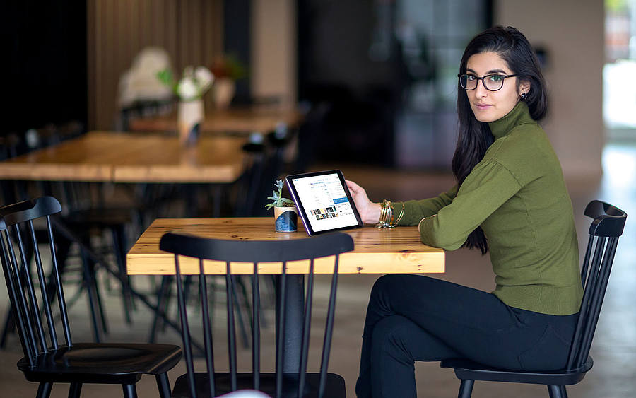 Frau sitzt m Tablet, Mitarbeiterin im Büro
