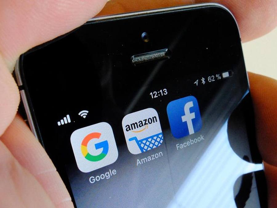 Logos der US-Internetkonzerne Google (l-r), Amazon und Facebook sind auf dem Display eines iPhons. Foto: Stefan Jaitner/dpa