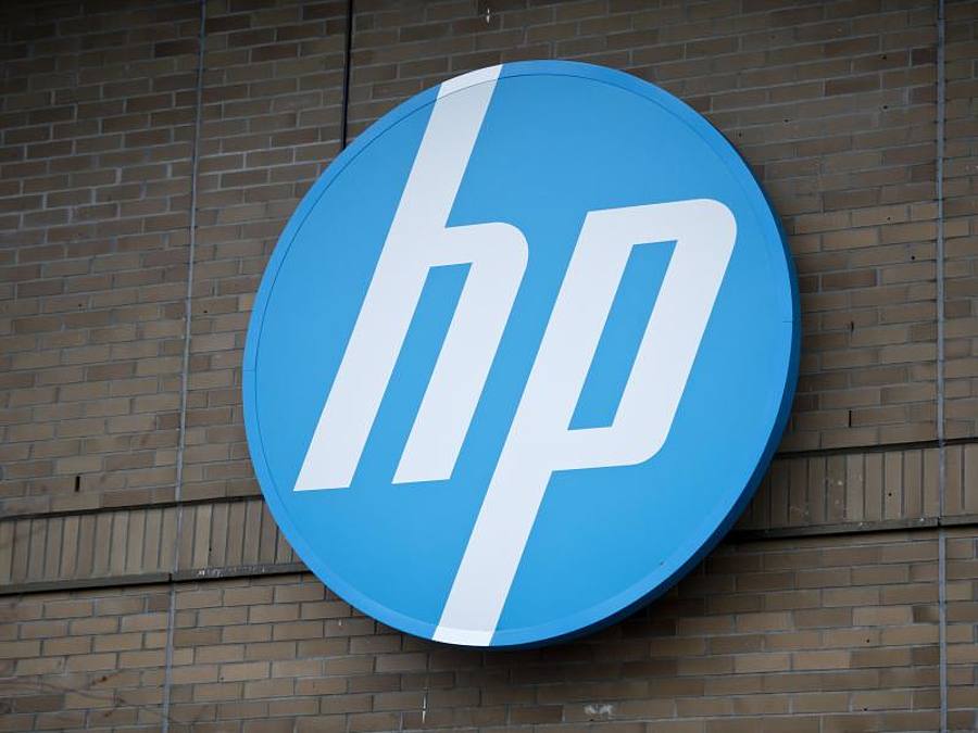 Das Logo der Firma Dell auf dem Gehäuse eines Laptops spiegelt sich im Bildschirm eines Smartphones. Foto: Monika Skolimowska/ZB/dpa